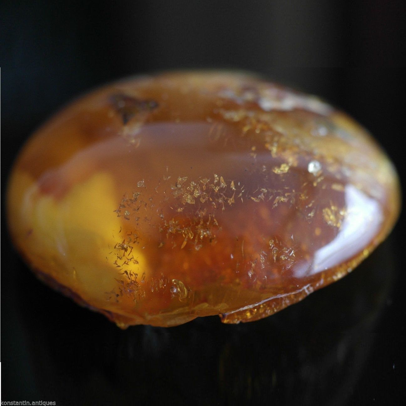 Piedra en bruto pulida de ámbar báltico auténtico en el marco de exposición.