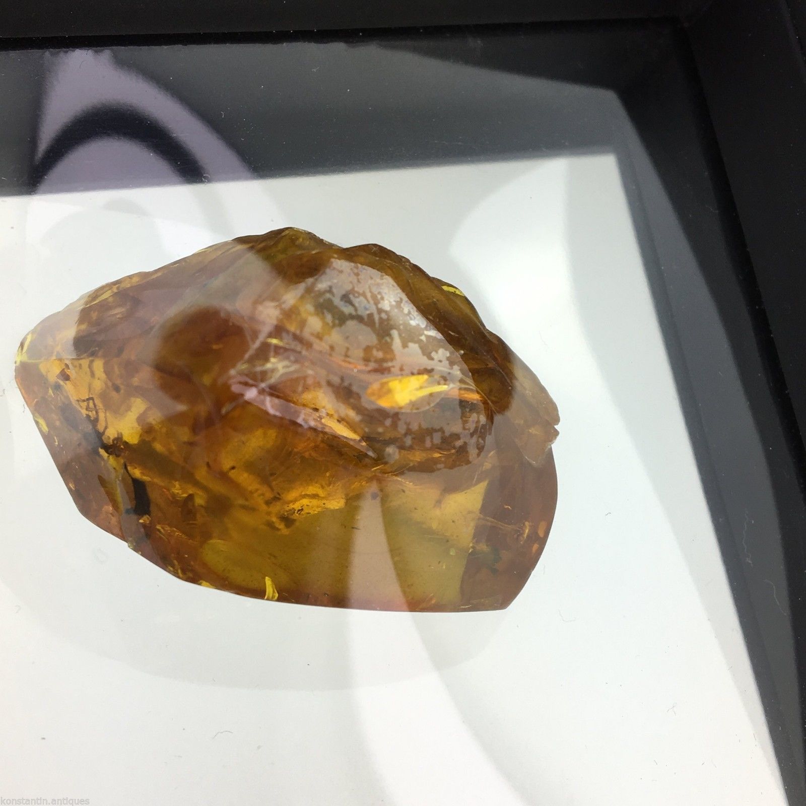 Piedra auténtica de ámbar báltico con inclusión en marco de exhibición. 