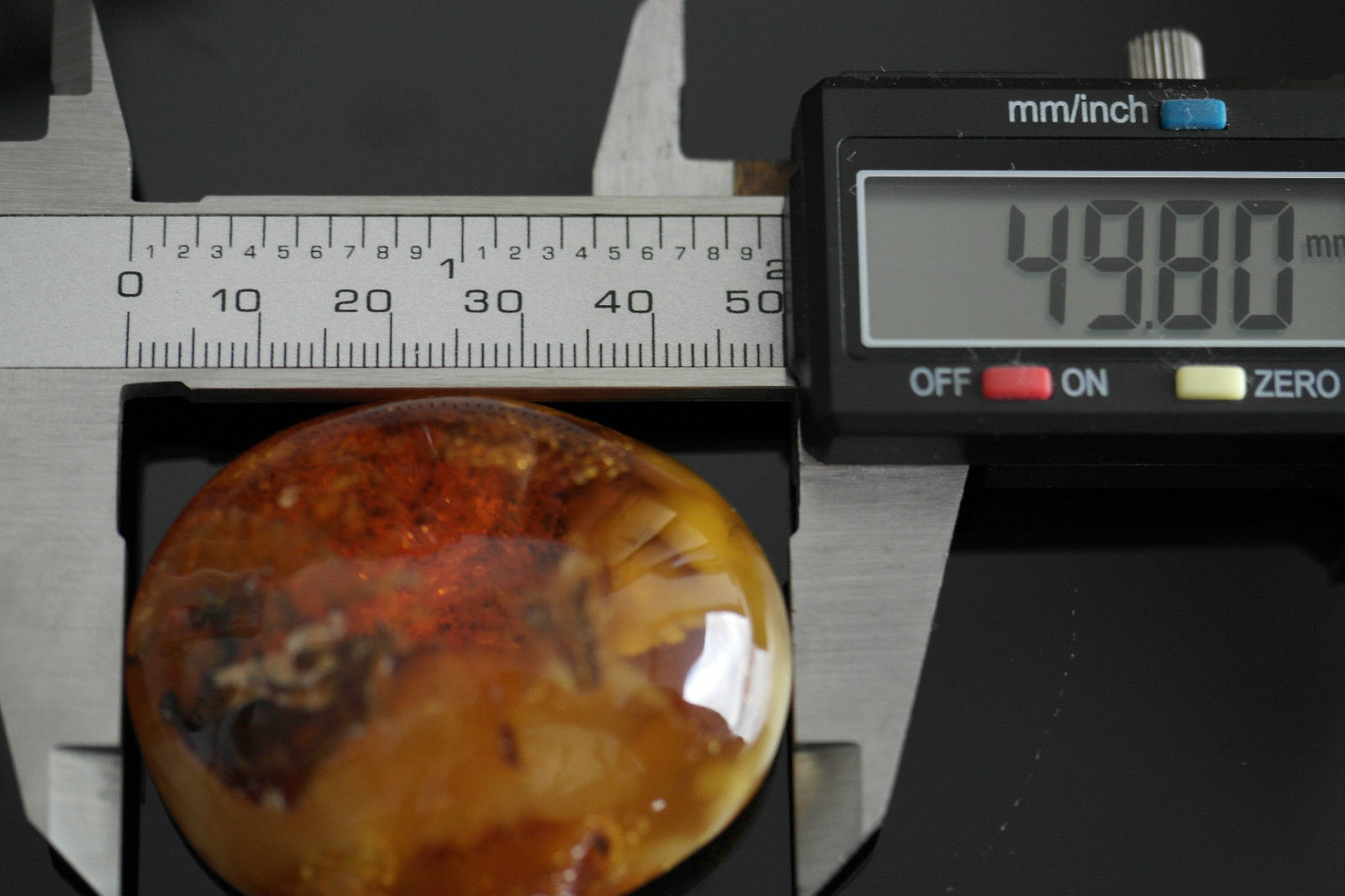 Piedra en bruto pulida de ámbar báltico auténtico en el marco de exposición.