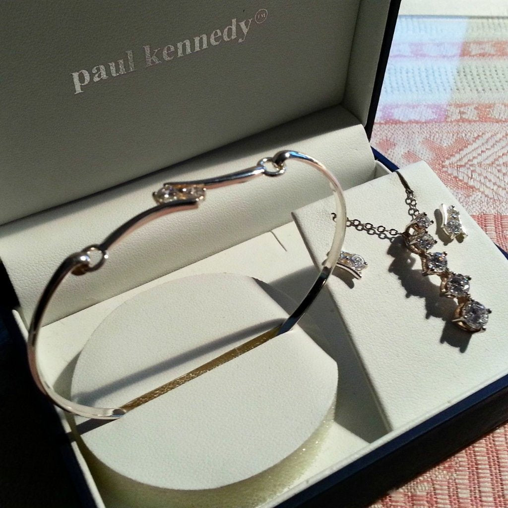 Conjunto con incrustaciones de brazalete, aretes, cadena y colgante de plata de ley con circonitas cúbicas.