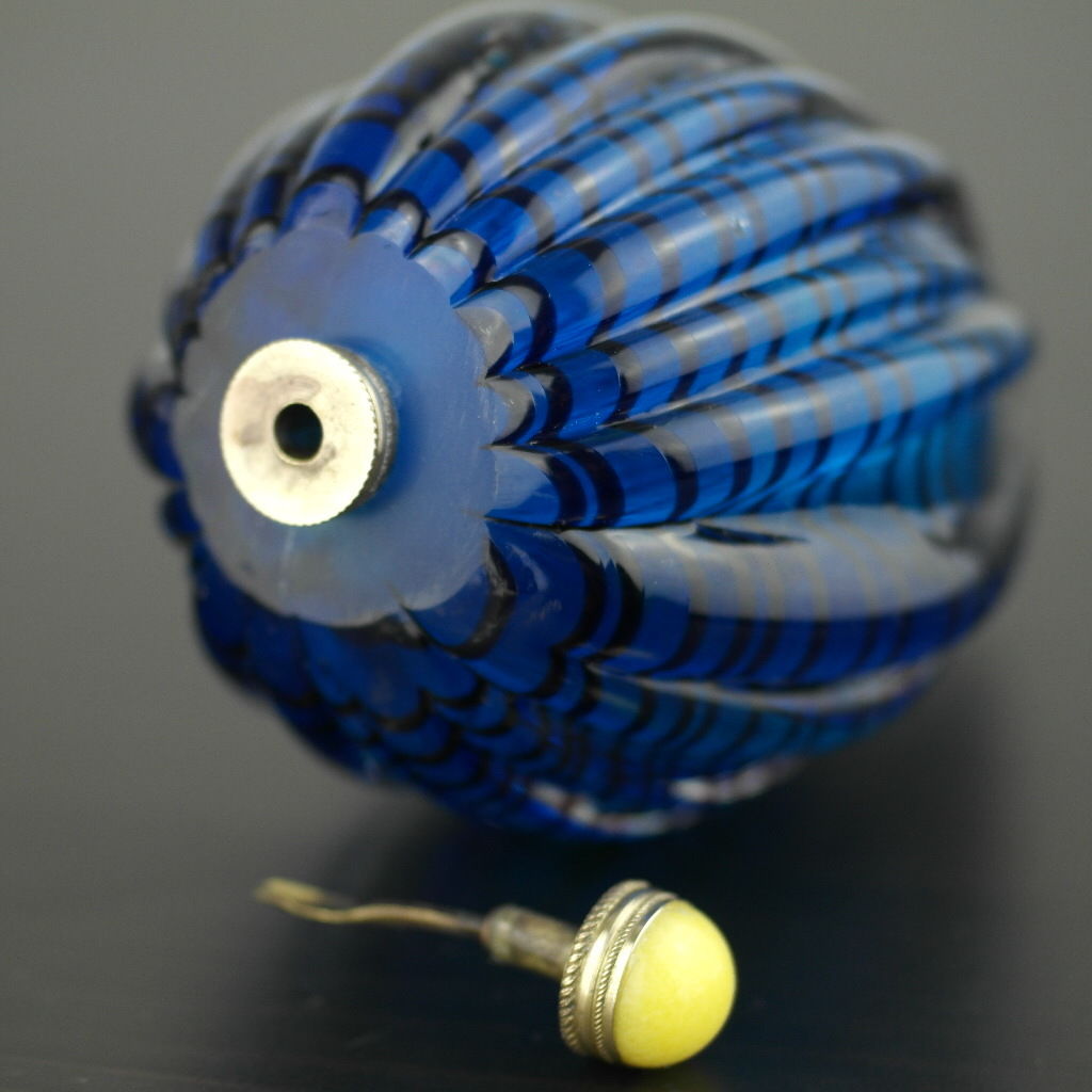 Antigua botella de rapé de vidrio azul con tapa de latón y jade amarillo en la parte superior