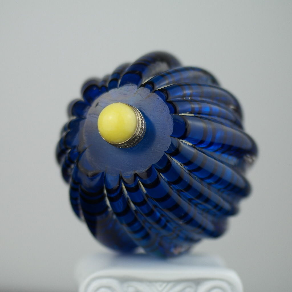 Antigua botella de rapé de vidrio azul con tapa de latón y jade amarillo en la parte superior
