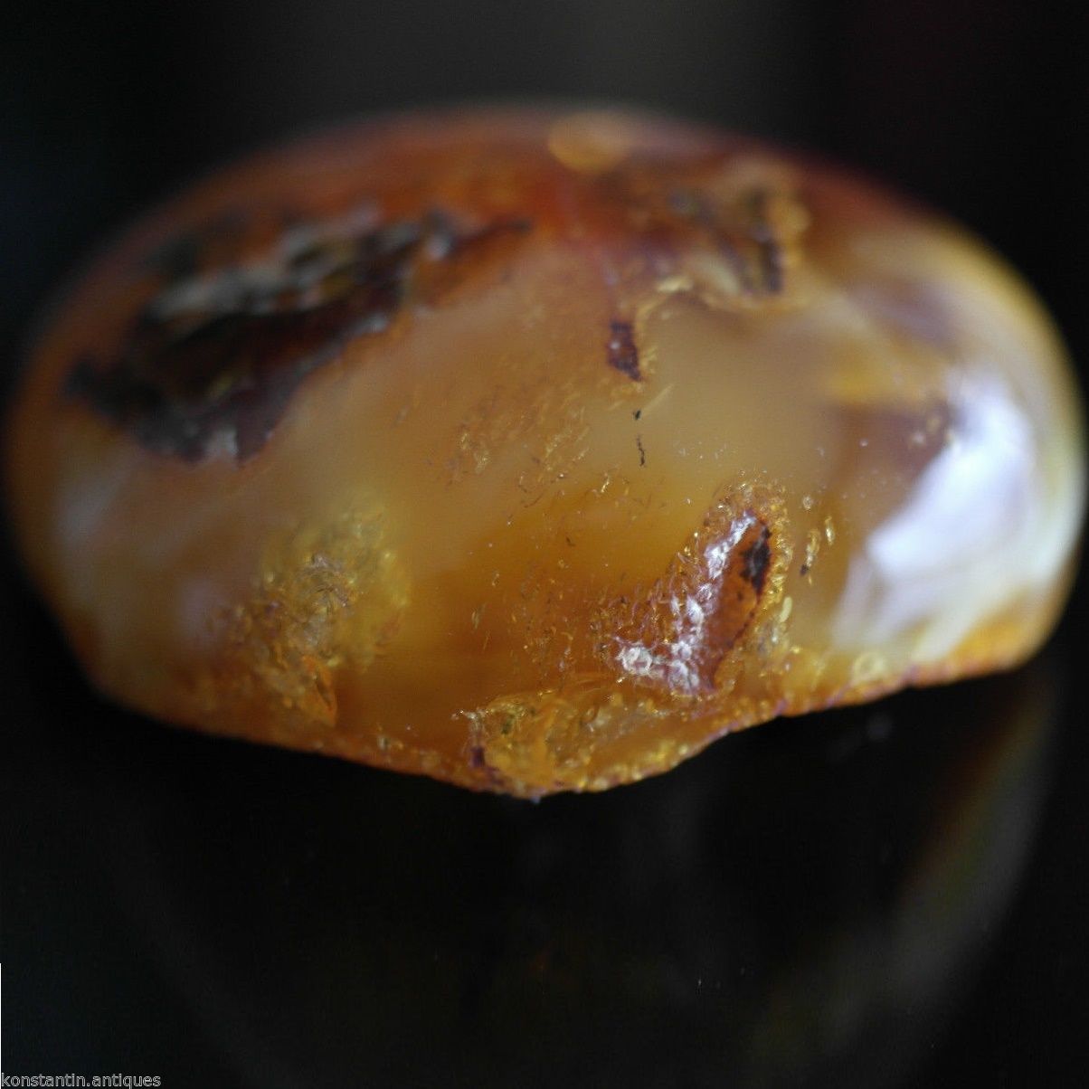 Piedra en bruto pulida de ámbar báltico auténtico en el marco de exposición.