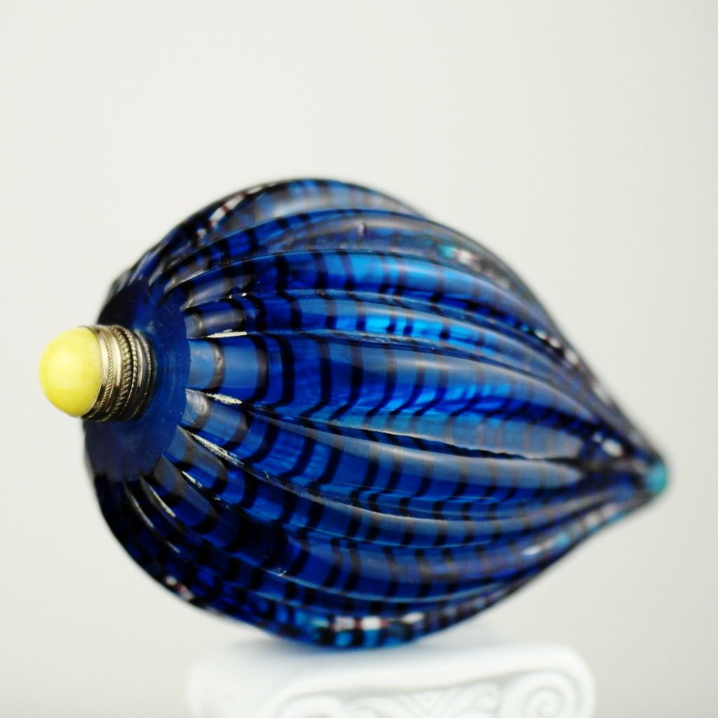 Antigua botella de rapé de vidrio azul con tapa de latón y jade amarillo en la parte superior