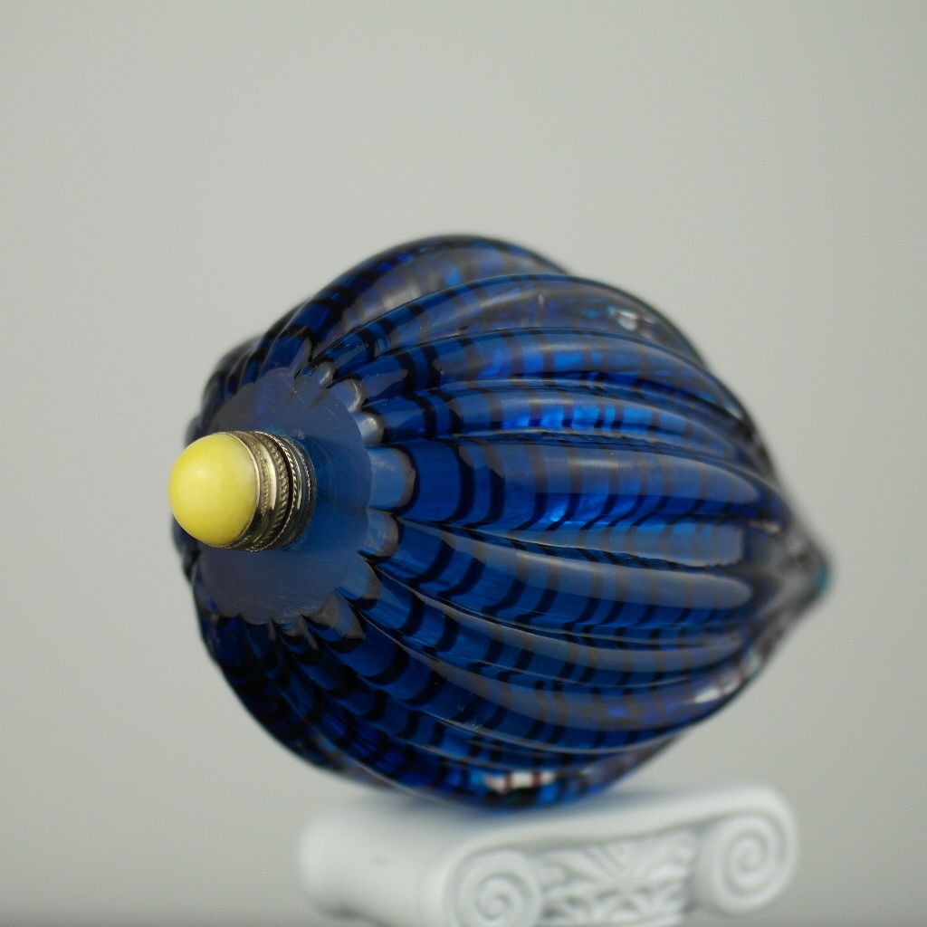Antigua botella de rapé de vidrio azul con tapa de latón y jade amarillo en la parte superior