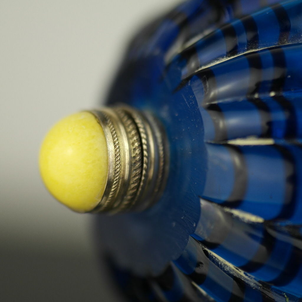 Antigua botella de rapé de vidrio azul con tapa de latón y jade amarillo en la parte superior