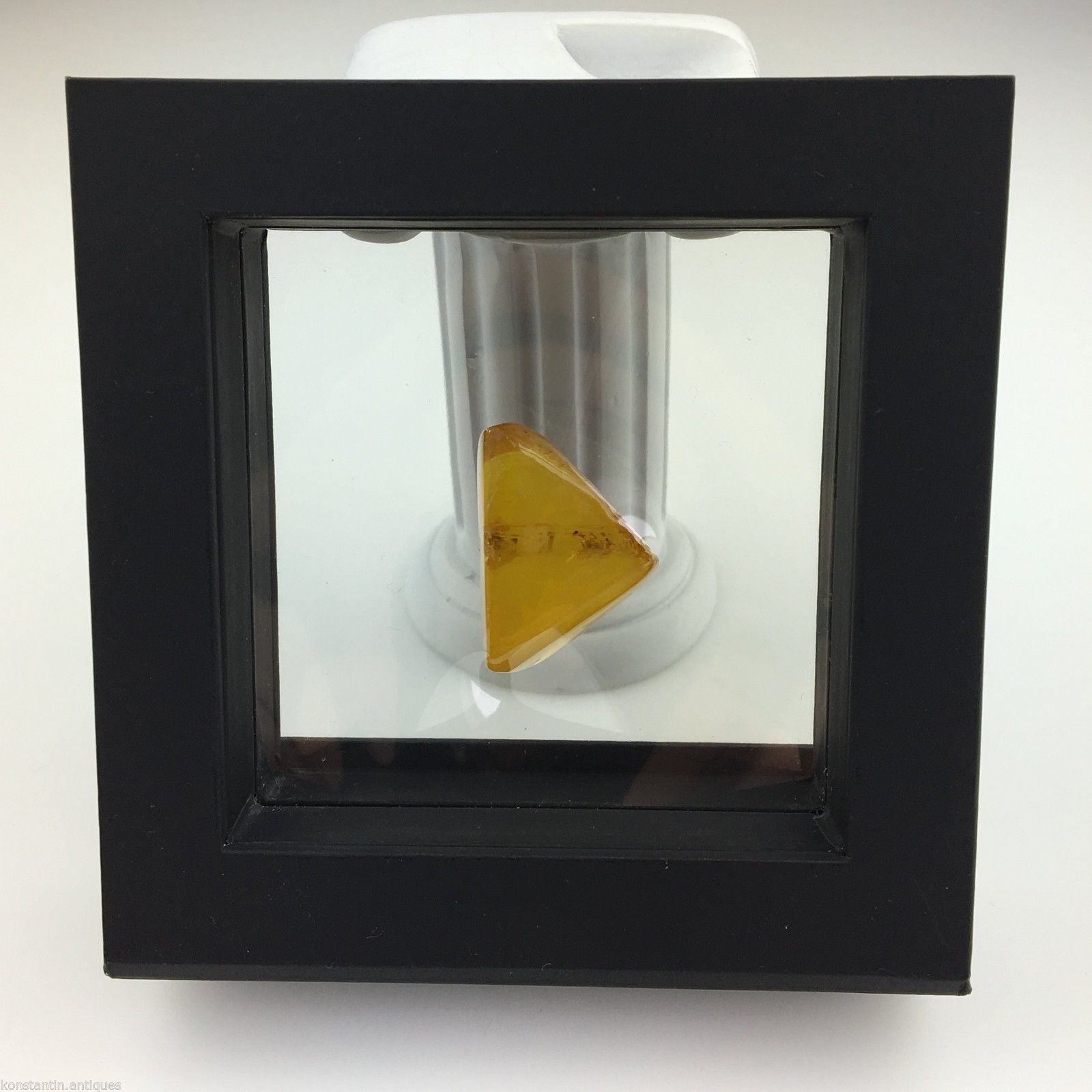 Piedra auténtica de ámbar báltico con inclusión en marco de exhibición.