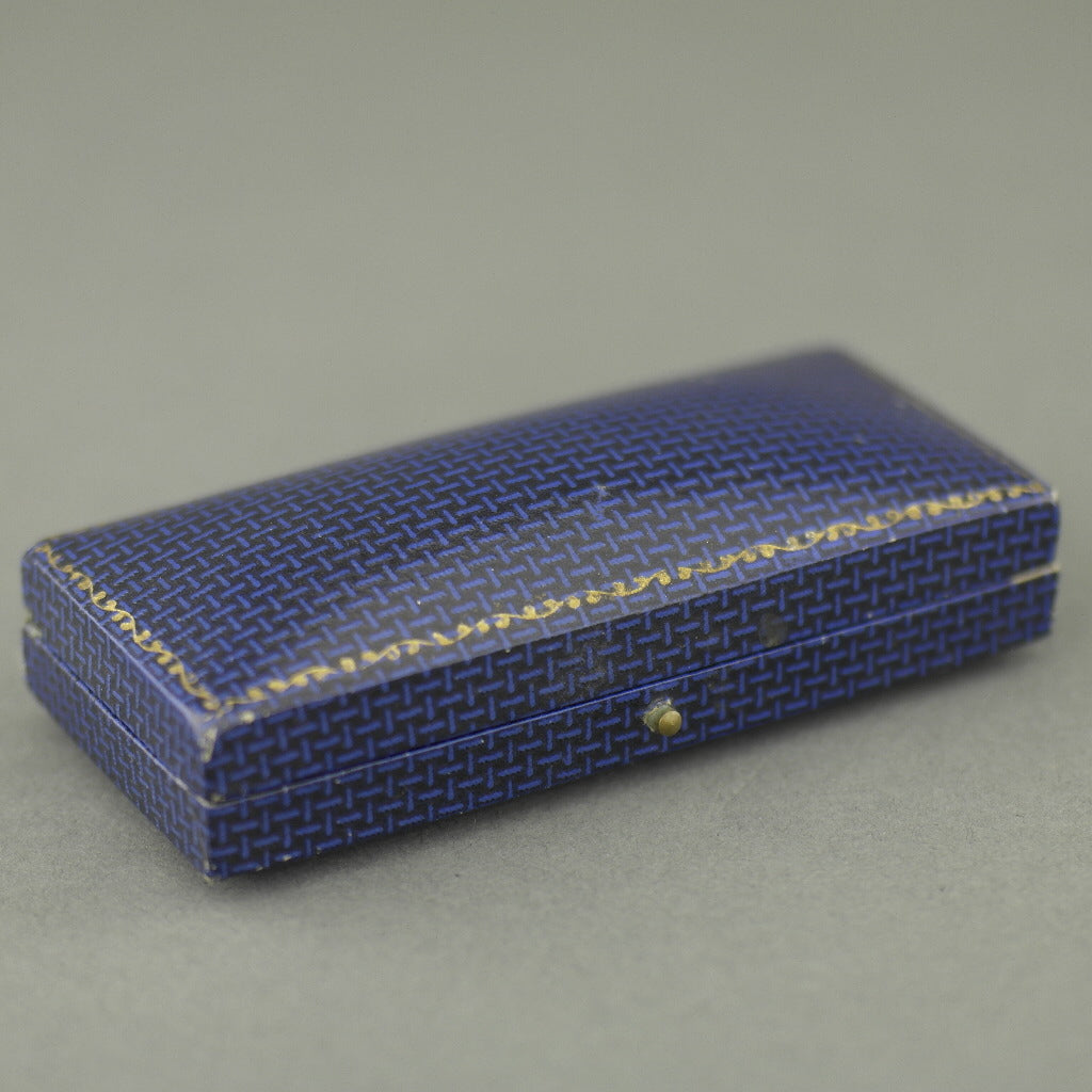 Caja antigua para juego de gemelos y tachuelas fabricada en el Imperio Británico.