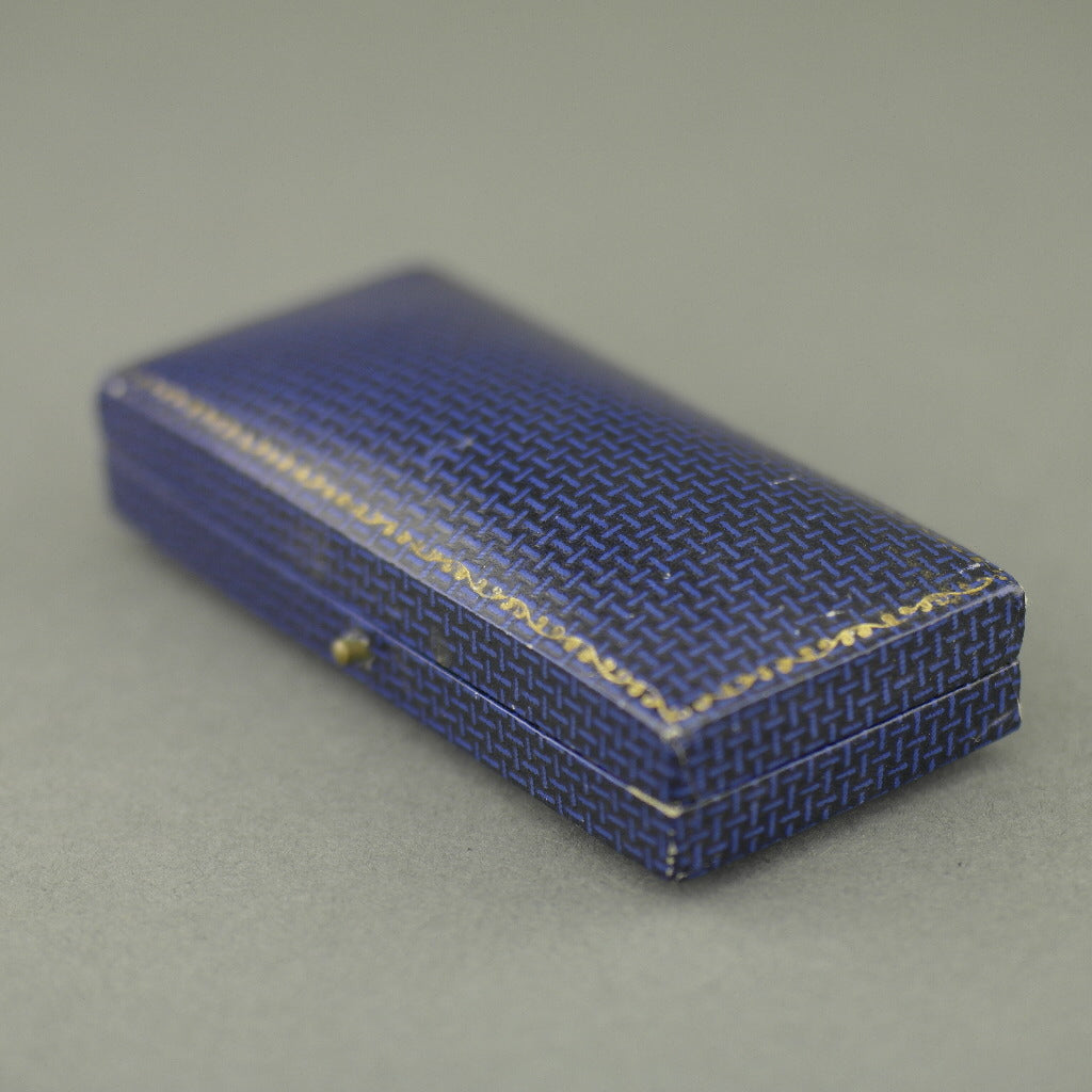 Caja antigua para juego de gemelos y tachuelas fabricada en el Imperio Británico.