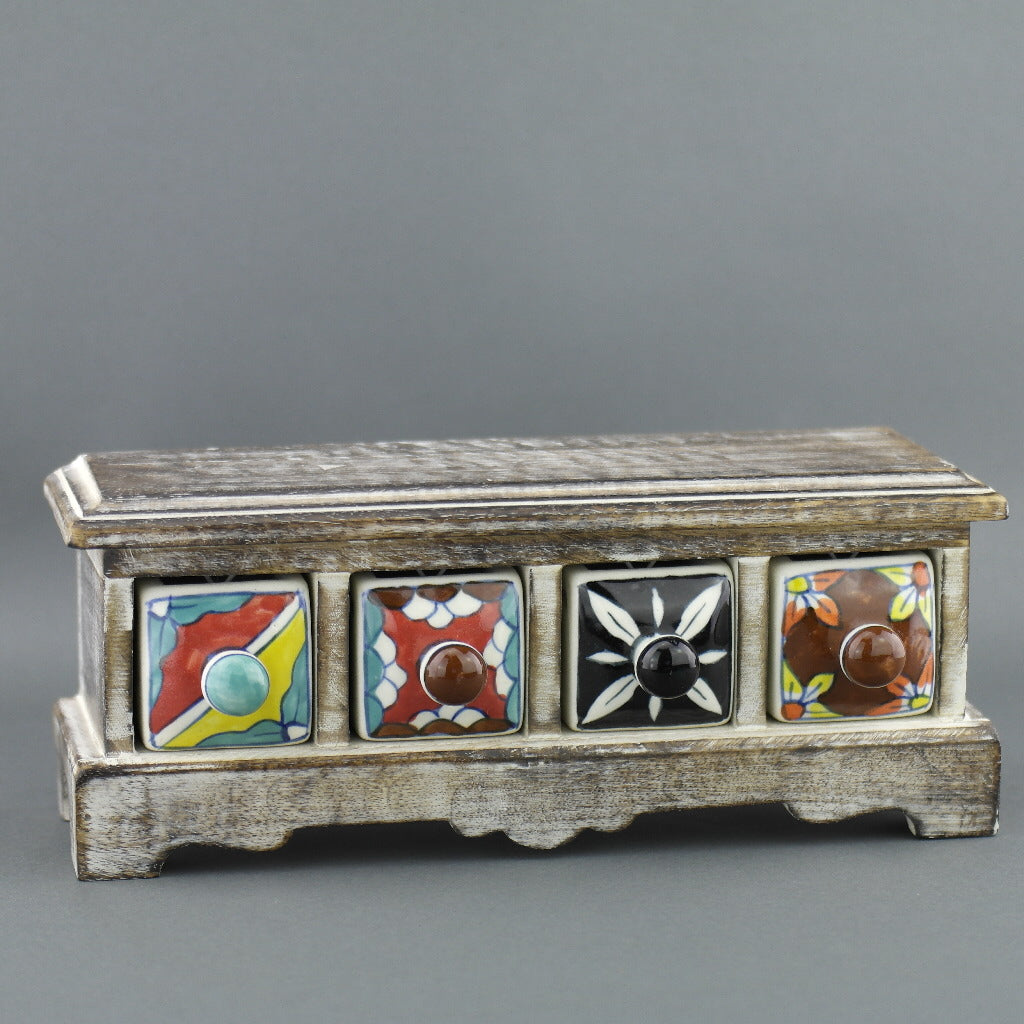 Cómoda de madera con cajones de cerámica para bolsitas de té.