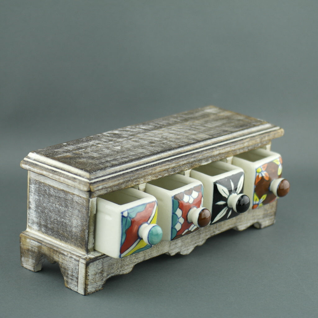 Cómoda de madera con cajones de cerámica para bolsitas de té.