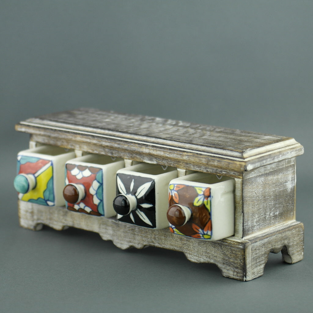 Cómoda de madera con cajones de cerámica para bolsitas de té.
