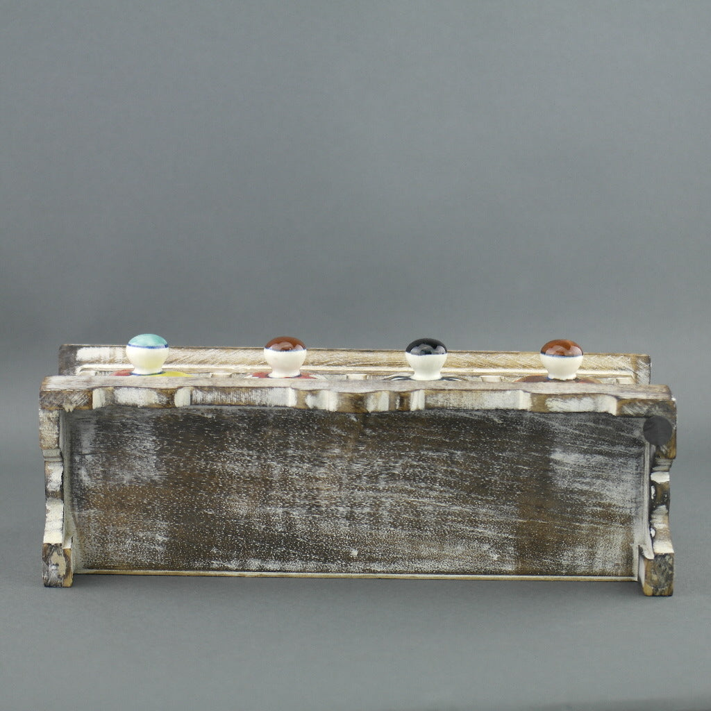 Cómoda de madera con cajones de cerámica para bolsitas de té.