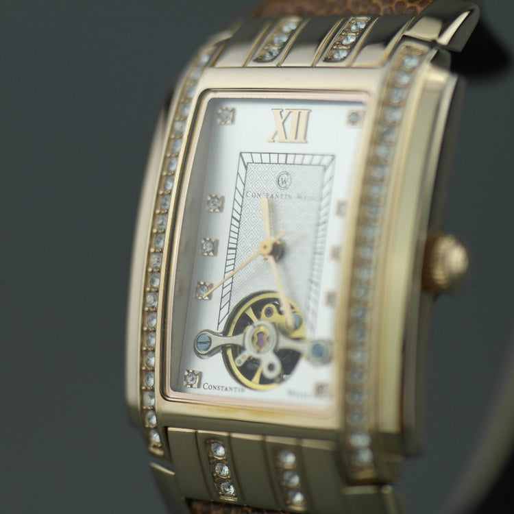 Reloj mecánico Constantin Weisz chapado en oro con correa de piel marrón.