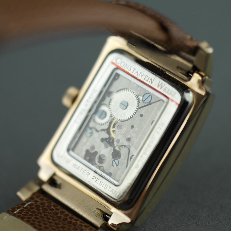 Reloj mecánico Constantin Weisz chapado en oro con correa de piel marrón.
