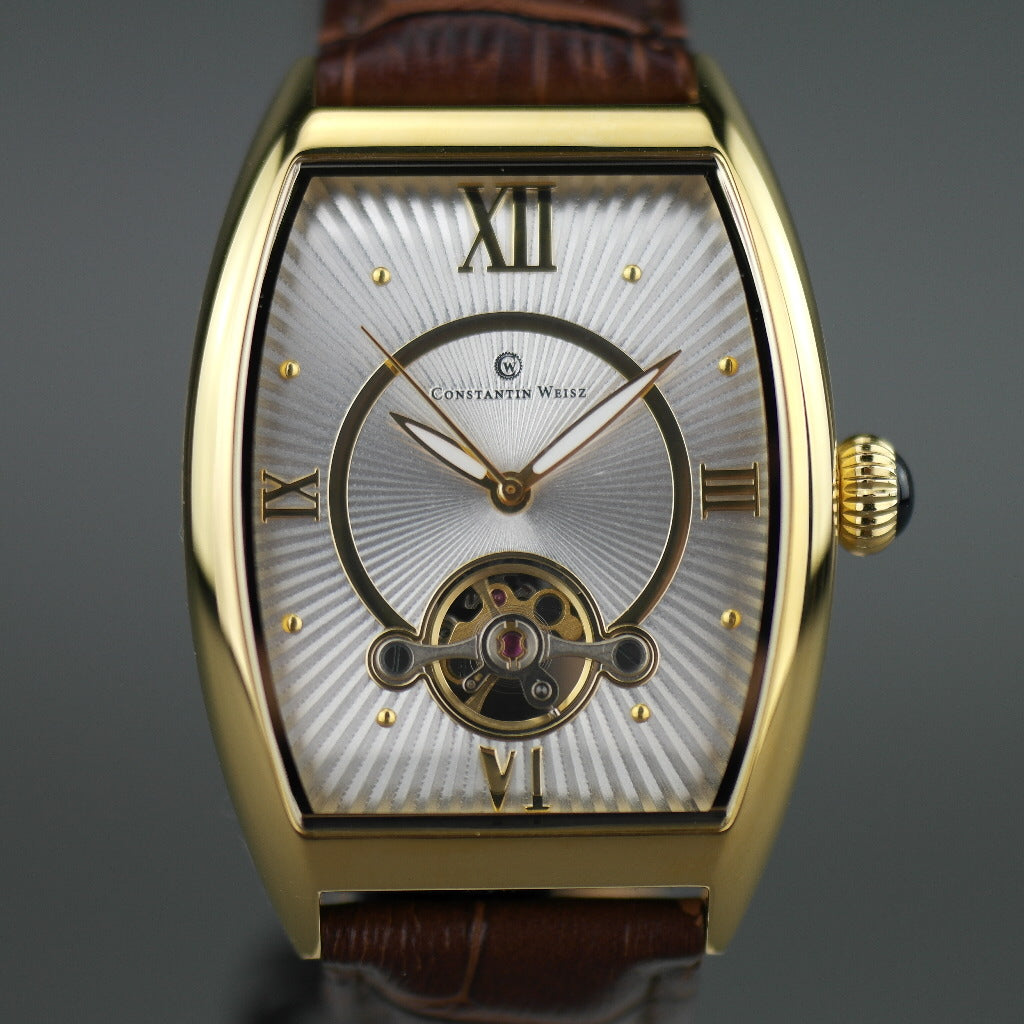 Reloj mecánico Constantin Weisz chapado en oro con correa de piel marrón.
