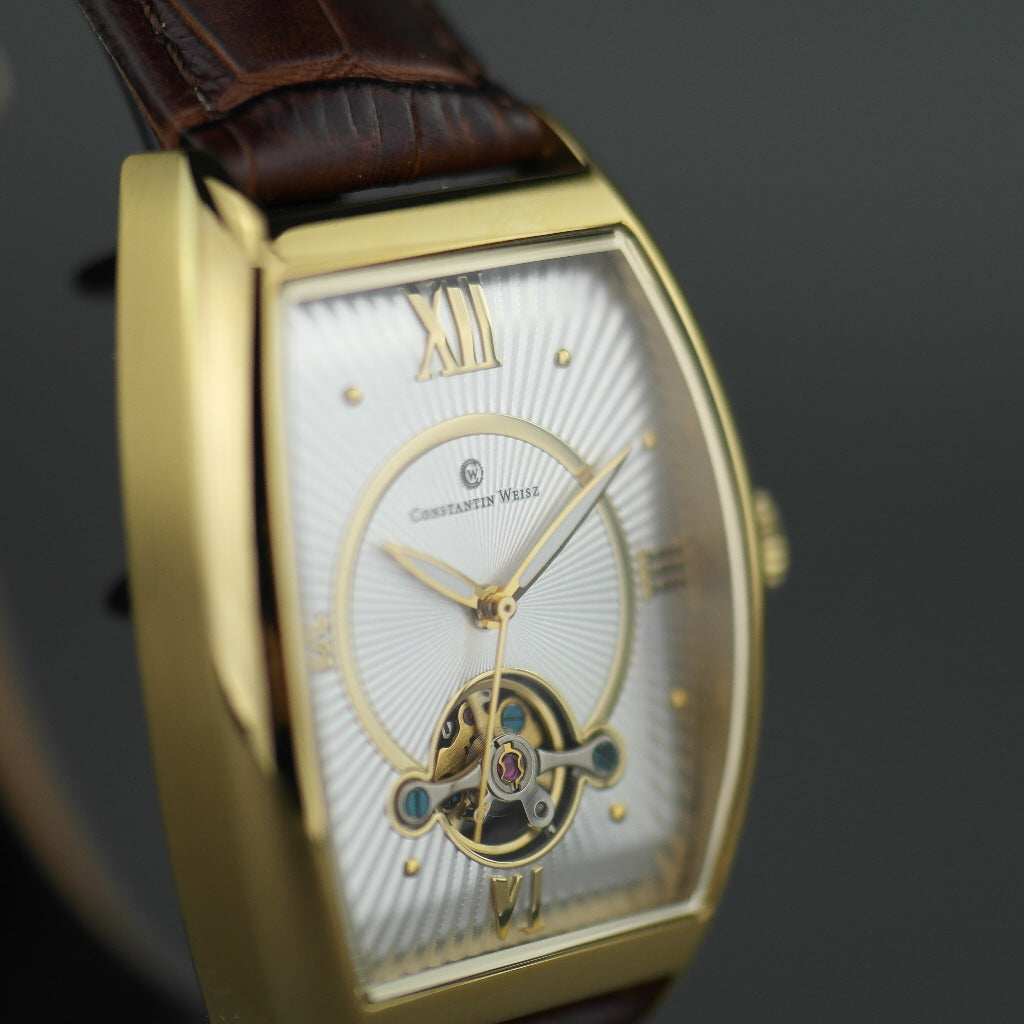 Reloj mecánico Constantin Weisz chapado en oro con correa de piel marrón.
