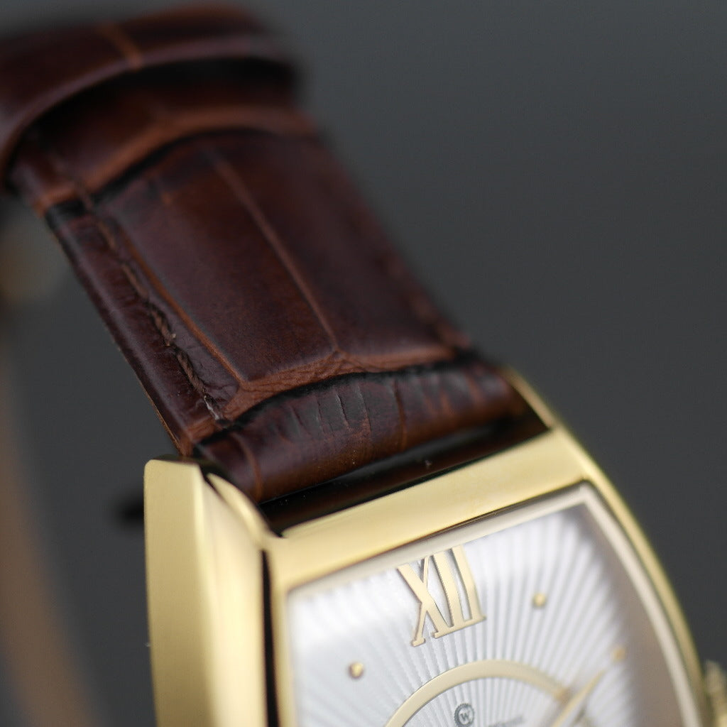 Reloj mecánico Constantin Weisz chapado en oro con correa de piel marrón.