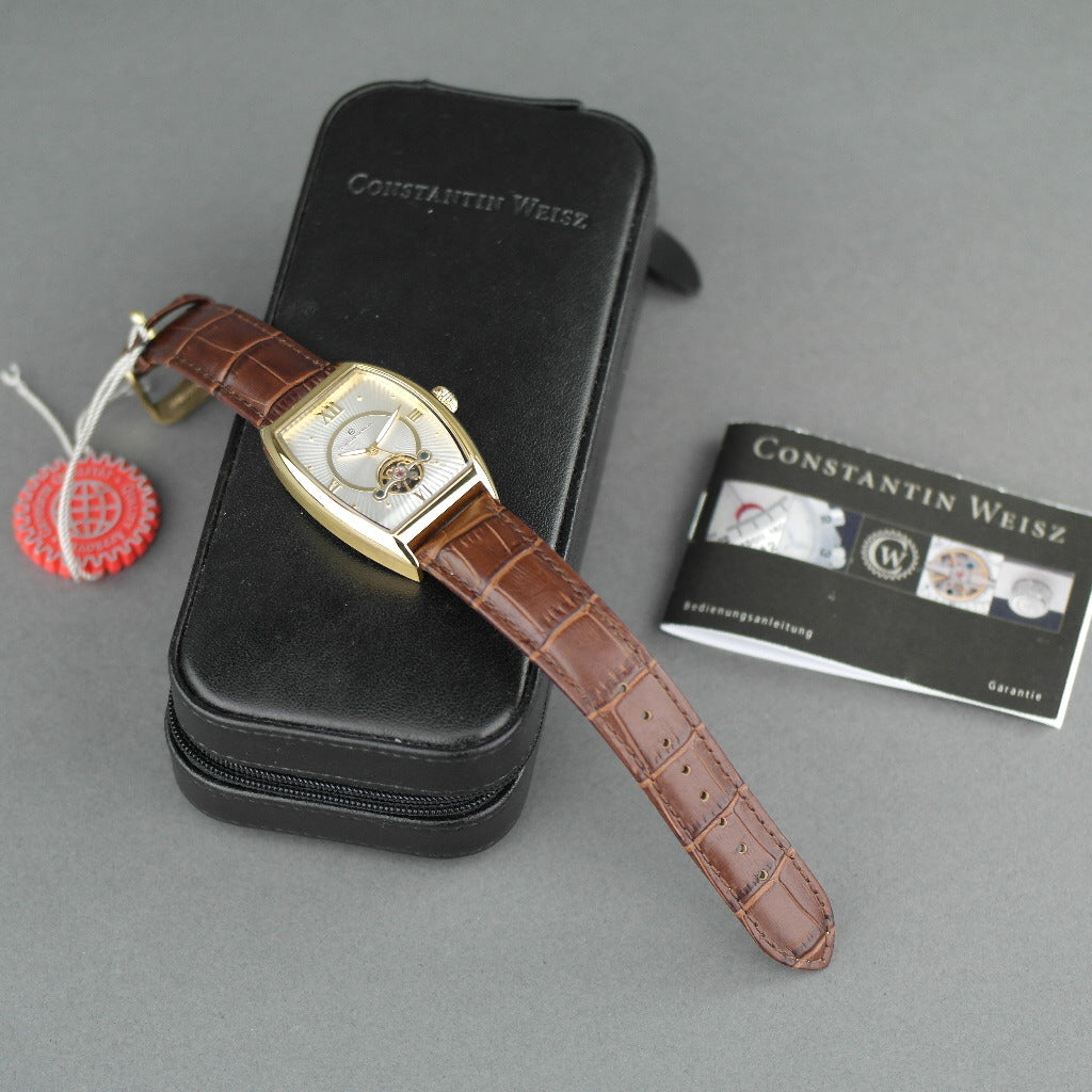 Reloj mecánico Constantin Weisz chapado en oro con correa de piel marrón.