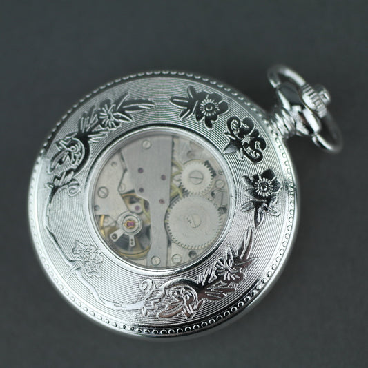 Reloj de bolsillo bañado en plata con números romanos e indicador de día y noche.