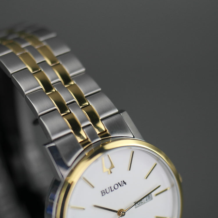 Reloj automático Bulova para hombre con esfera blanca y fecha bilingüe con pulsera de acero inoxidable y elementos chapados en oro