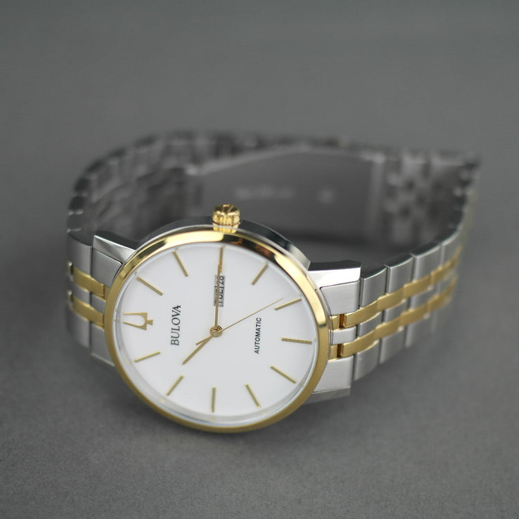 Reloj automático Bulova para hombre con esfera blanca y fecha bilingüe con pulsera de acero inoxidable y elementos chapados en oro